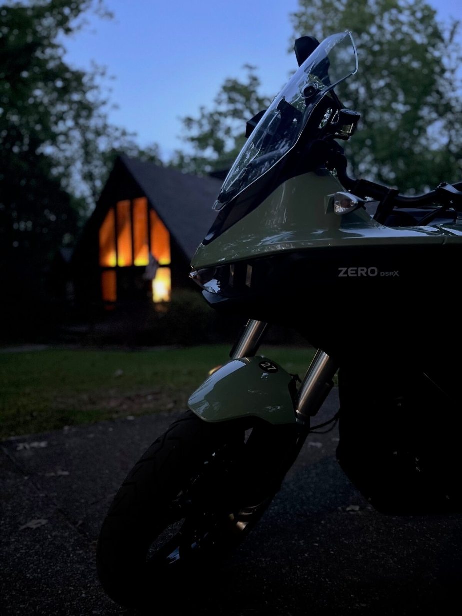 2023 Zero DSR/X parked in front of a cabin a dusk.